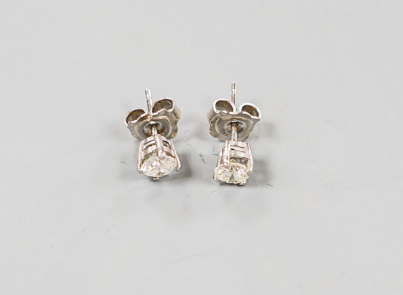 A pair of 750 white metal and solitaire diamond ear studs, gross weight 1.8 grams